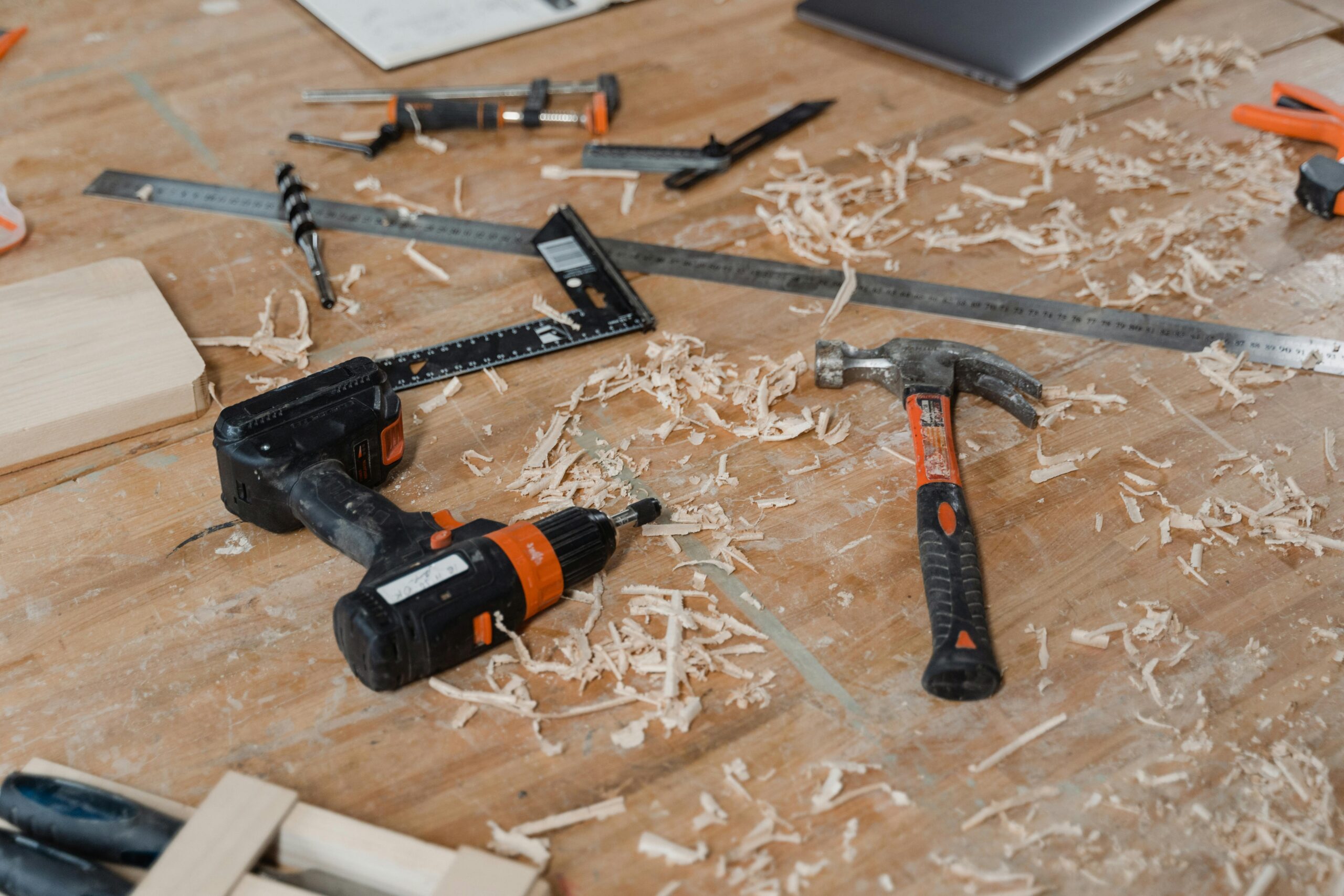 A close-up view of various woodworking tools scattered on a wooden surface with sawdust.